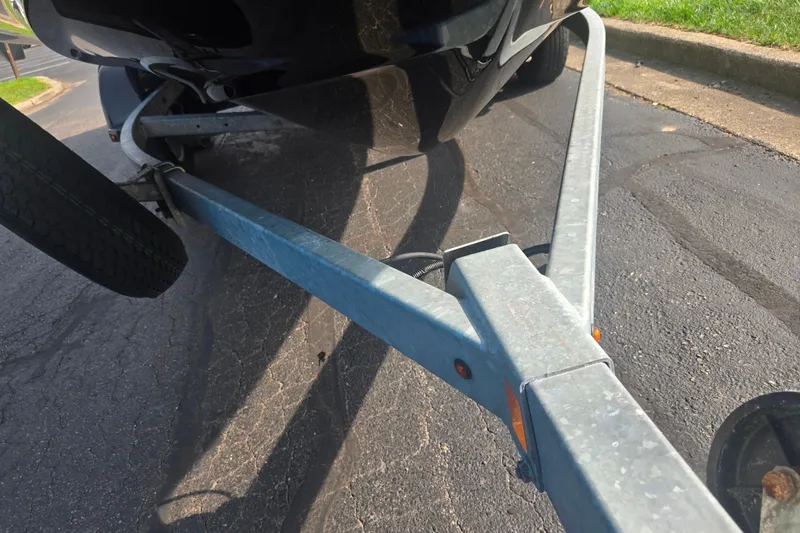 Slide: The Image of Trailer for 2022 Yamaha Boats AR210 on pavement, showcasing sturdy construction. - 7