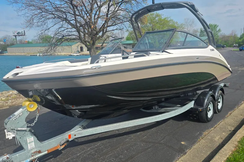 Slide: The Image of 2022 Yamaha Boats AR210 on trailer by a lakeside road. - 8