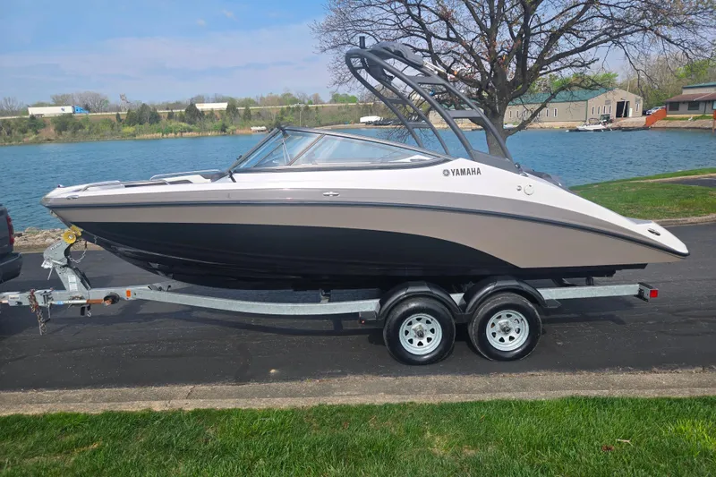 Slide: The Image of 2022 Yamaha AR210 boat on trailer by a lake, showcasing sleek design. - 9