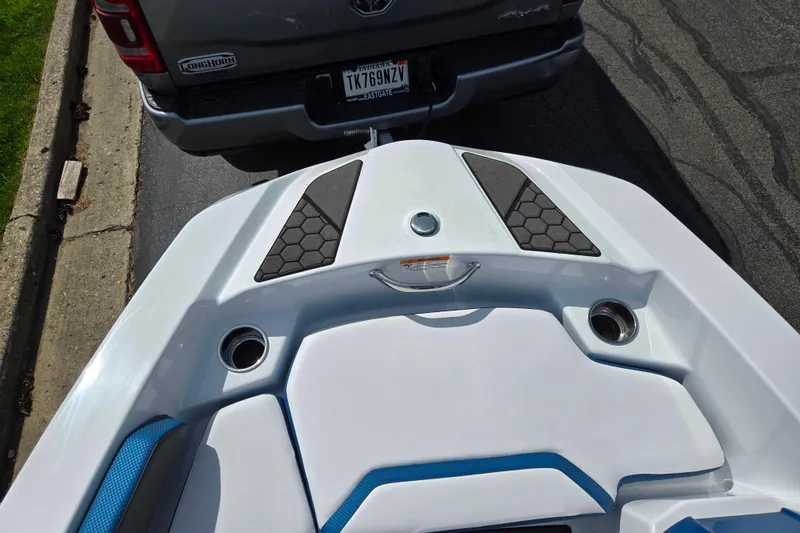 Slide: The Image of 2021 Scarab 165 ID boat hitched to a truck, parked on a street. - 17