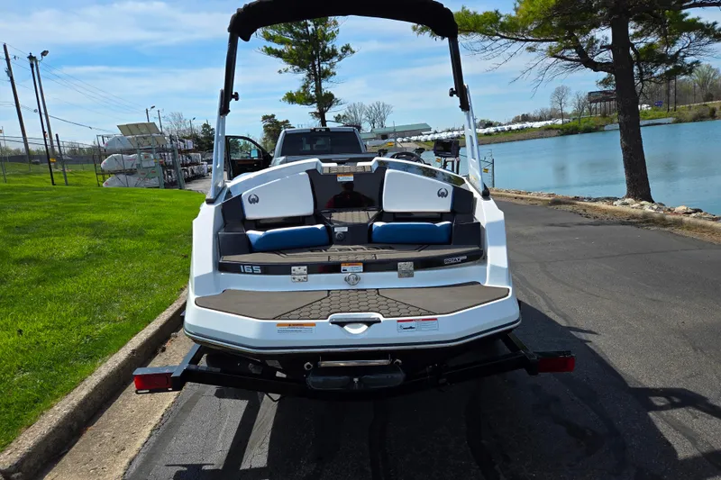 Slide: The Image of 2021 Scarab 165 ID boat on trailer by a lakeside road. - 2