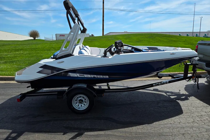 Slide: The Image of 2021 Scarab 165 ID boat on trailer, parked outdoors under blue sky. - 4
