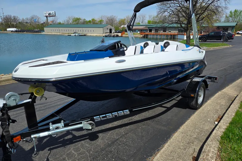 Slide: The Image of 2021 Scarab 165 ID boat on trailer by a lake, showcasing sleek design and modern features. - 8