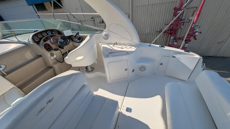 Slide: The Image of 2004 Sea Ray 280 Sundancer cockpit with seating, steering wheel, and control panel. - 14