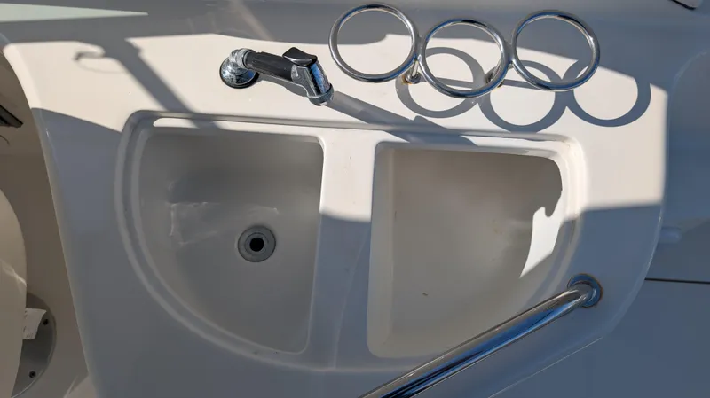 Slide: The Image of 2004 Sea Ray 280 Sundancer boat sink with faucet and cup holders. - 17