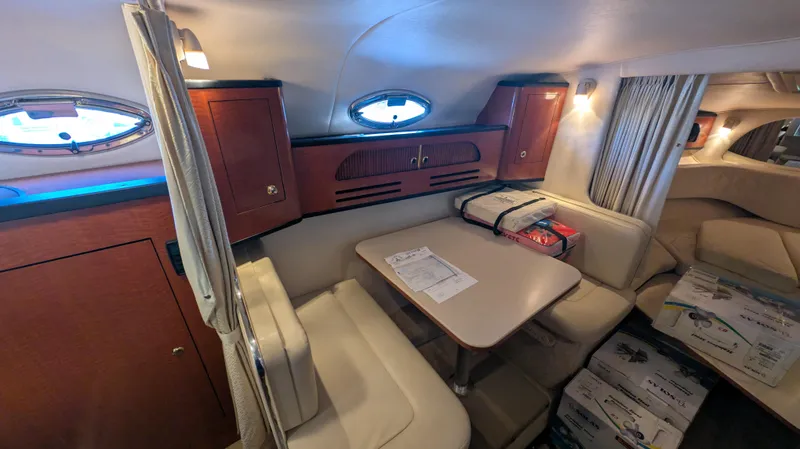Slide: The Image of Interior of 2004 Sea Ray 280 Sundancer with dining area and wooden cabinetry. - 23