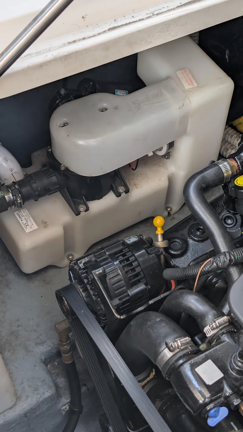 Slide: The Image of Engine compartment of a 2004 Sea Ray 280 Sundancer boat, showcasing mechanical components. - 33
