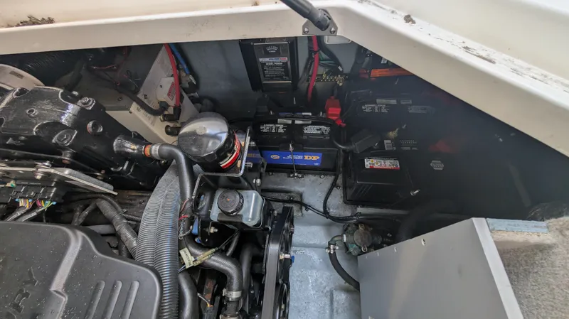 Slide: The Image of Engine compartment of a 2004 Sea Ray 280 Sundancer, showcasing batteries and mechanical components. - 34