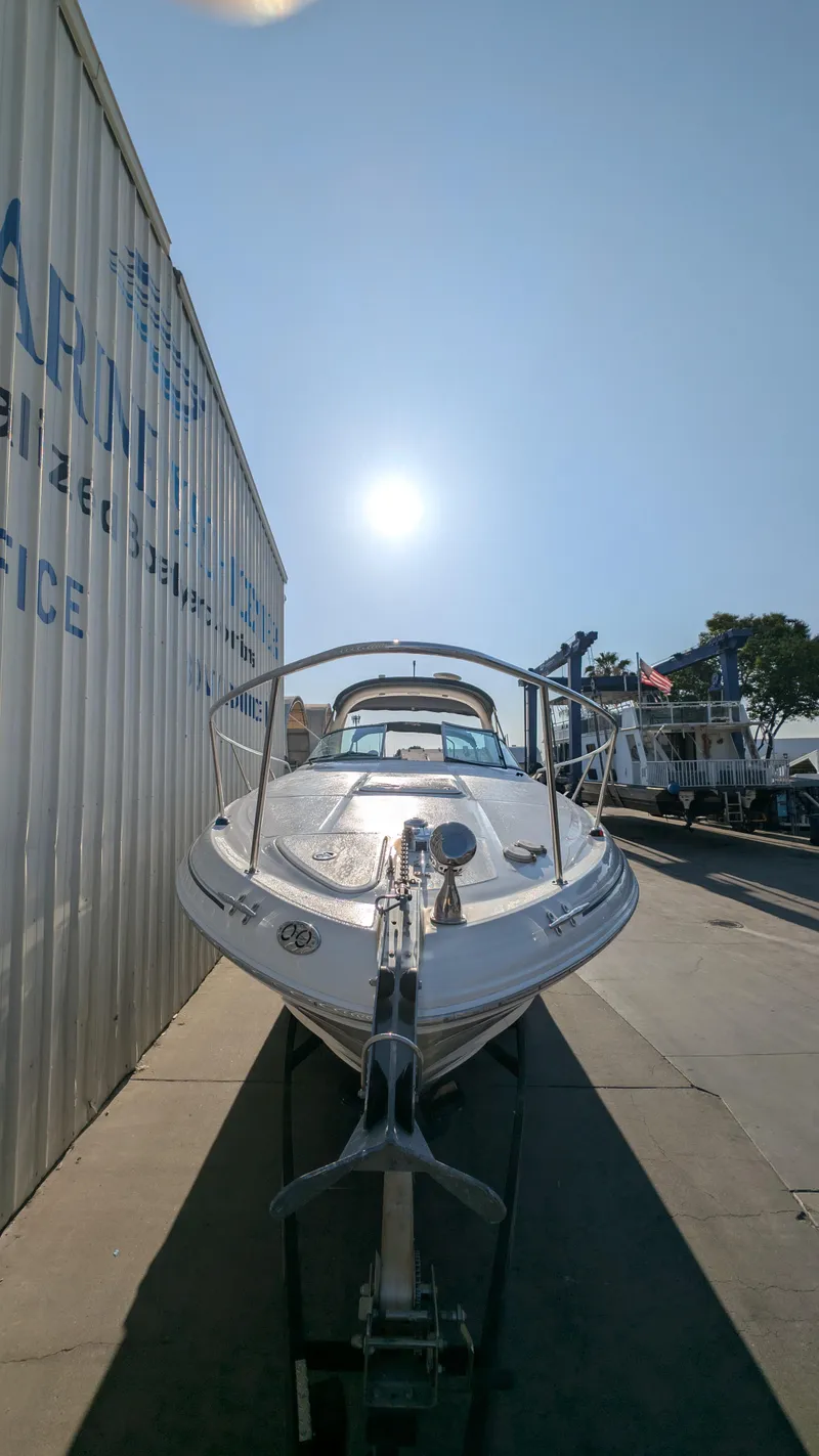 Slide: The Image of 2004 Sea Ray 280 Sundancer boat on trailer under bright sun. - 4