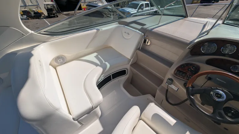 Slide: The Image of 2004 Sea Ray 280 Sundancer cockpit with white seating and steering wheel. - 9