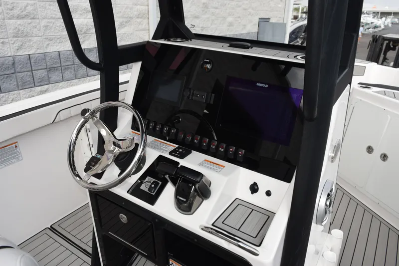 Slide: The Image of 2021 Yamaha Boats 255 FSH Sport E helm with steering wheel and control panel. - 9