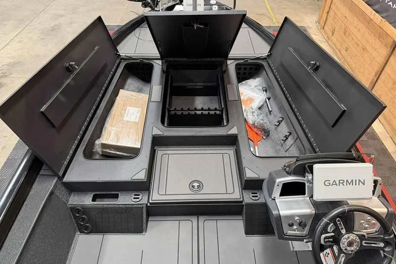 Slide: The Image of 2026 Tracker Savage 215 boat interior with open storage compartments and Garmin navigation system. - 13