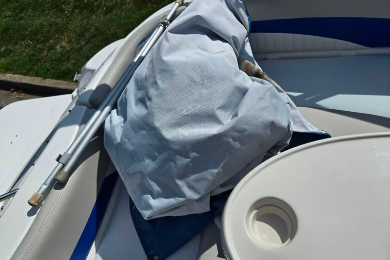 Slide: The Image of 2006 Glastron DX 235 boat interior with covered equipment and cup holder. - 10