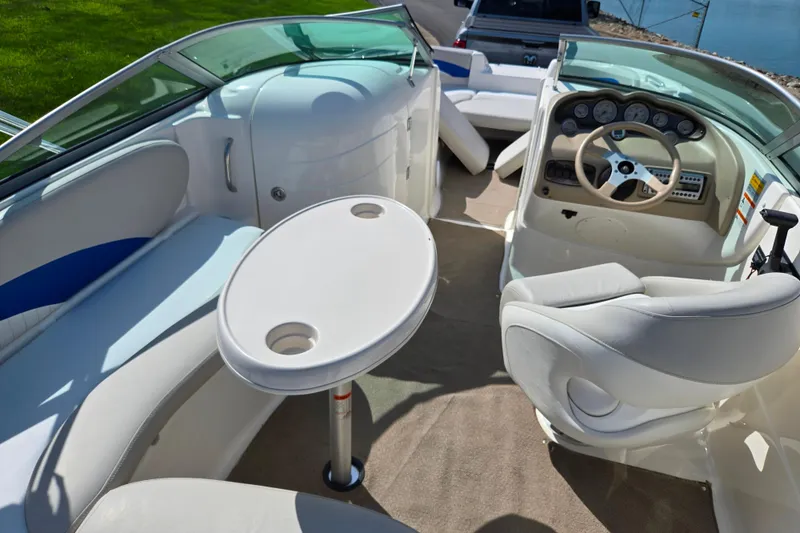 Slide: The Image of Interior of 2006 Glastron DX 235 boat with seating, table, and steering console. - 12