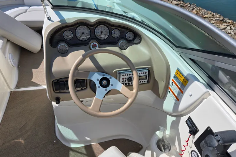 Slide: The Image of 2006 Glastron DX 235 boat dashboard with steering wheel and gauges. - 14
