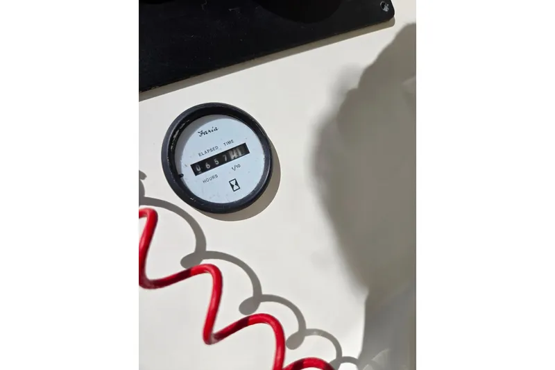Slide: The Image of Hour meter on 2006 Glastron DX 235 boat dashboard with red coiled cable. - 16