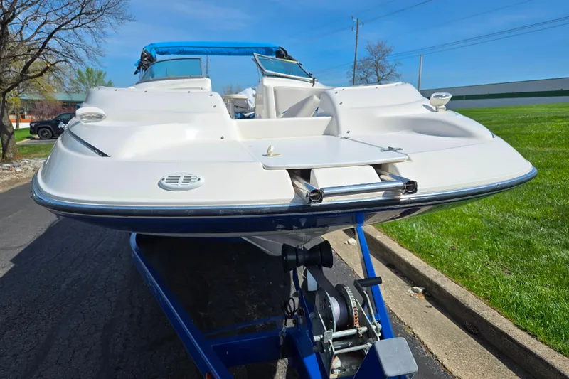 Slide: The Image of 2006 Glastron DX 235 boat on trailer, white hull, blue accents, sunny day. - 6