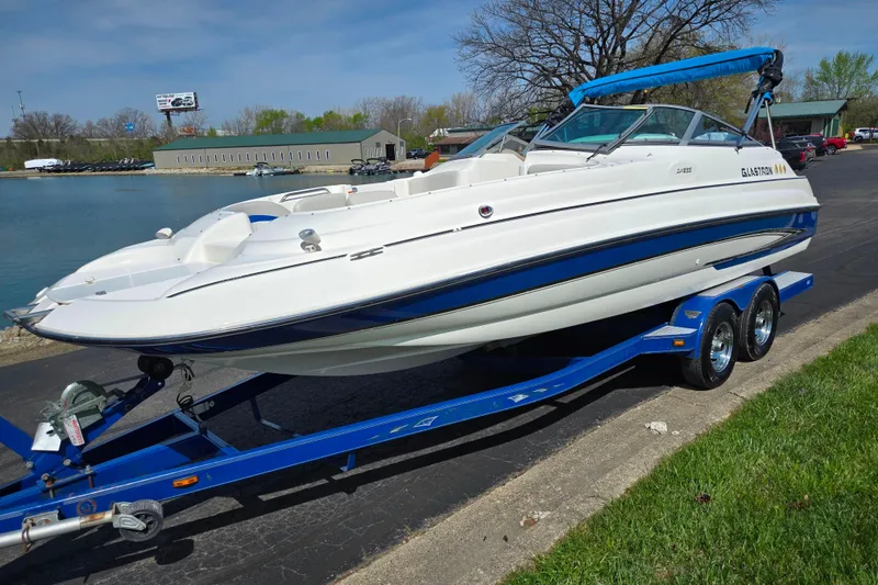 Slide: The Image of 2006 Glastron DX 235 boat on blue trailer by a lakeside, sunny day. - 8