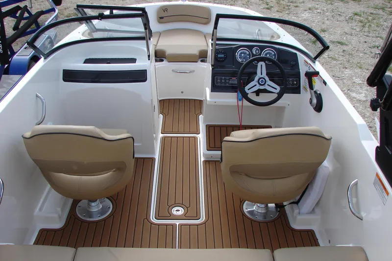 Slide: The Image of 2021 Bayliner VR4 Bowrider I/O interior with tan seats and wood-style flooring. - 10