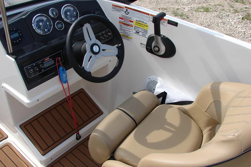 Slide: The Image of 2021 Bayliner VR4 Bowrider I/O dashboard with steering wheel and beige seating. - 13