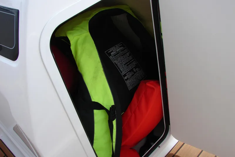 Slide: The Image of Storage compartment with life jackets on a 2021 Bayliner VR4 Bowrider I/O boat. - 30