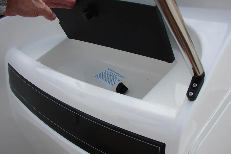 Slide: The Image of 2021 Bayliner VR4 Bowrider I/O storage compartment with open lid and hand. - 32