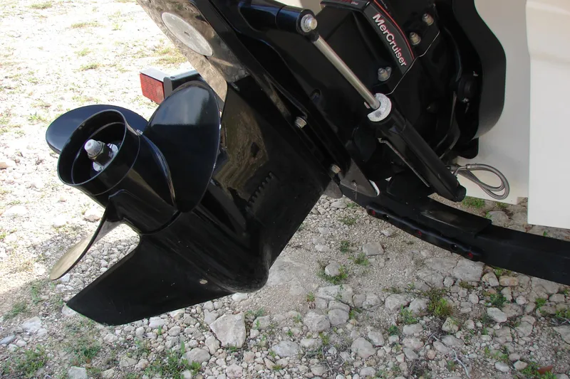 Slide: The Image of 2021 Bayliner VR4 Bowrider I/O boat engine and propeller on rocky ground. - 6