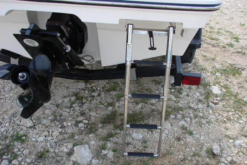 Slide: The Image of 2021 Bayliner VR4 Bowrider I/O with ladder and propeller on rocky terrain. - 9