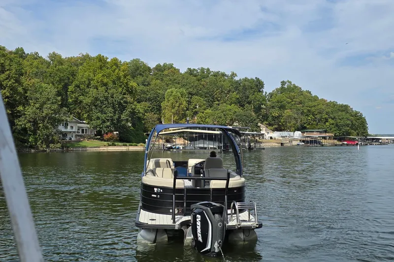 Slide: The Image of 2017 South Bay 725 RS pontoon boat on a scenic lake with lush green shoreline. - 2