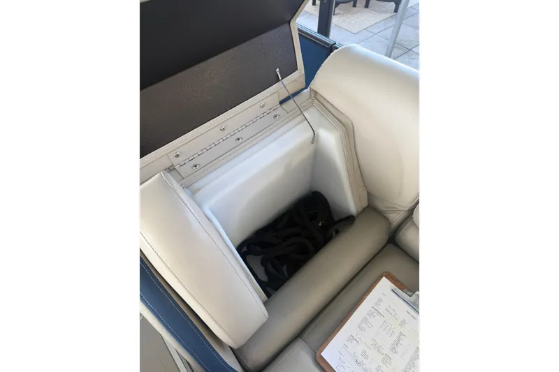Slide: The Image of Open storage compartment in 2017 South Bay 725 RS boat seat, showing interior and clipboard. - 25