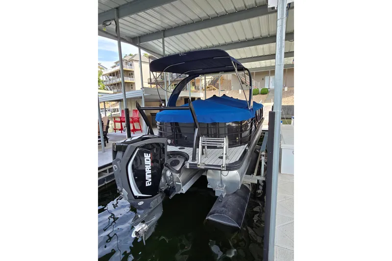 Slide: The Image of 2017 South Bay 725 RS pontoon boat with Evinrude motor, docked under a covered marina. - 4