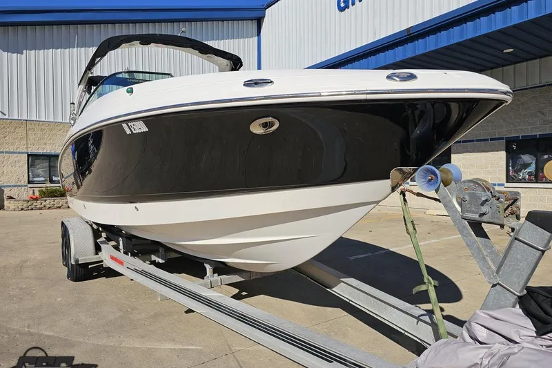 Slide: The Image of 2010 Chaparral 276 SSX boat on trailer, parked outside a building. - 11
