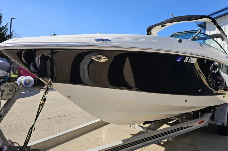 Slide: The Image of 2010 Chaparral 276 SSX boat on trailer, sleek black and white design. - 15