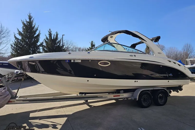Slide: The Image of 2010 Chaparral 276 SSX boat on trailer, parked outdoors under clear blue sky. - 16