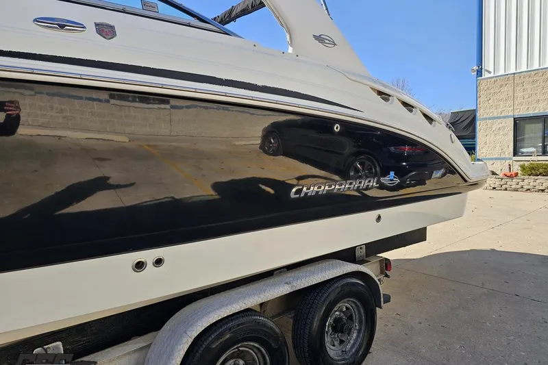 Slide: The Image of 2010 Chaparral 276 SSX boat on trailer, reflecting surroundings in glossy black hull. - 18