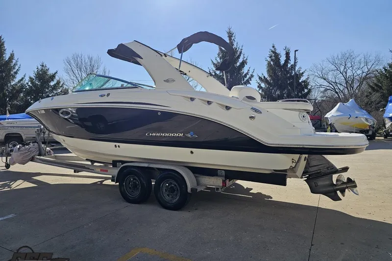 Slide: The Image of 2010 Chaparral 276 SSX boat on trailer, parked outdoors under clear sky. - 22