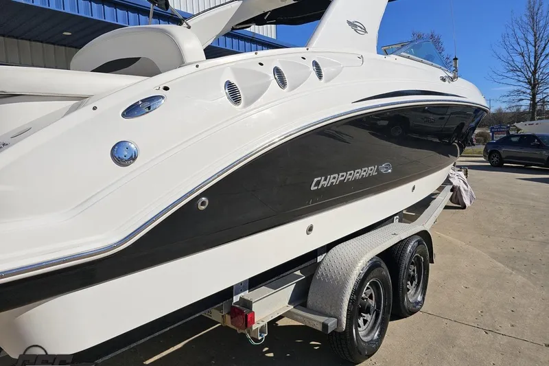 Slide: The Image of 2010 Chaparral 276 SSX boat on trailer, sleek design, white and black exterior. - 29