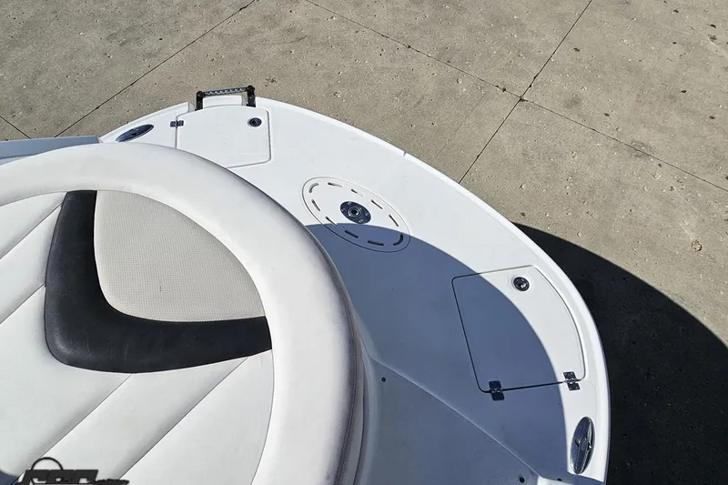 Slide: The Image of 2010 Chaparral 276 SSX boat deck with white seating and storage compartments. - 31