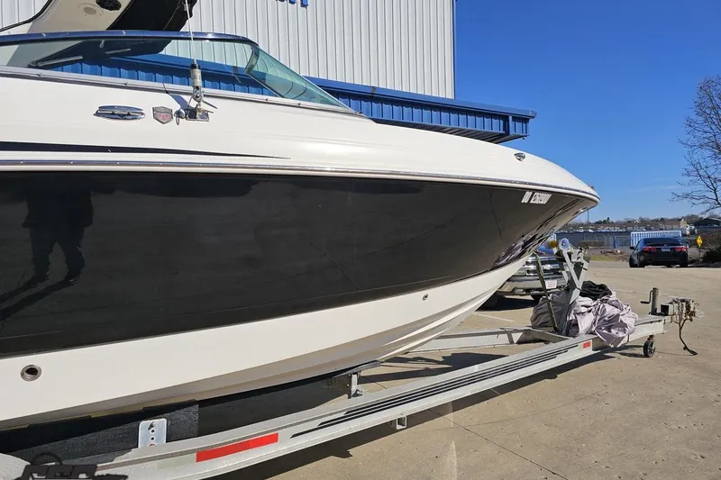 Slide: The Image of 2010 Chaparral 276 SSX boat on trailer, parked outdoors under clear blue sky. - 4