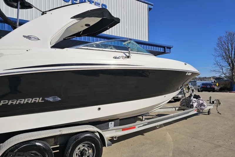 Slide: The Image of 2010 Chaparral 276 SSX boat on trailer, parked outdoors under clear blue sky. - 5