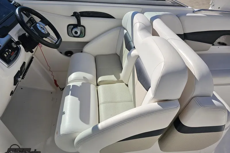 Slide: The Image of 2010 Chaparral 276 SSX boat interior with white seating and steering wheel. - 65