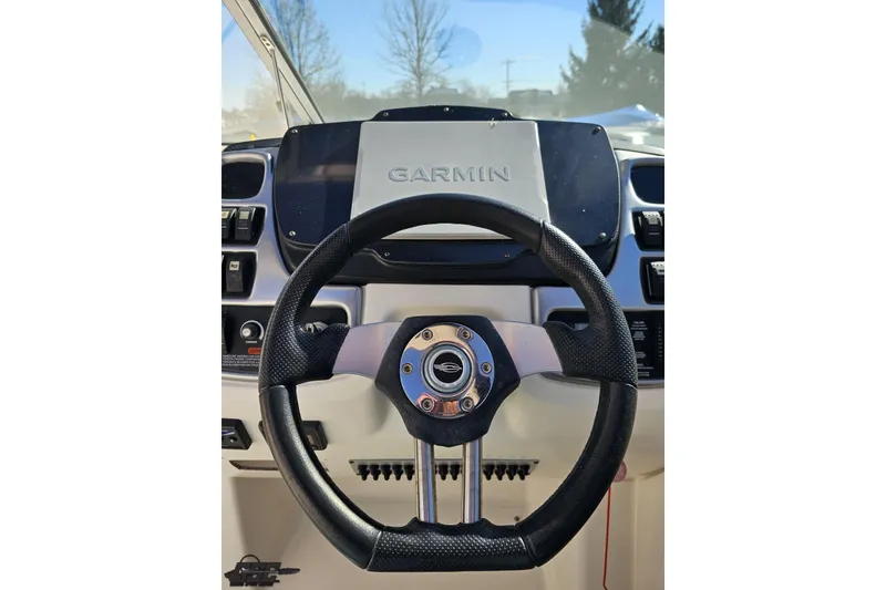 Slide: The Image of Steering wheel and Garmin display on 2010 Chaparral 276 SSX boat dashboard. - 71