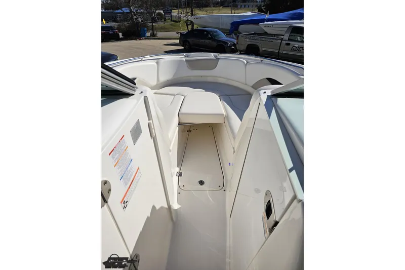 Slide: The Image of 2010 Chaparral 276 SSX boat interior with white seating and storage compartment. - 78