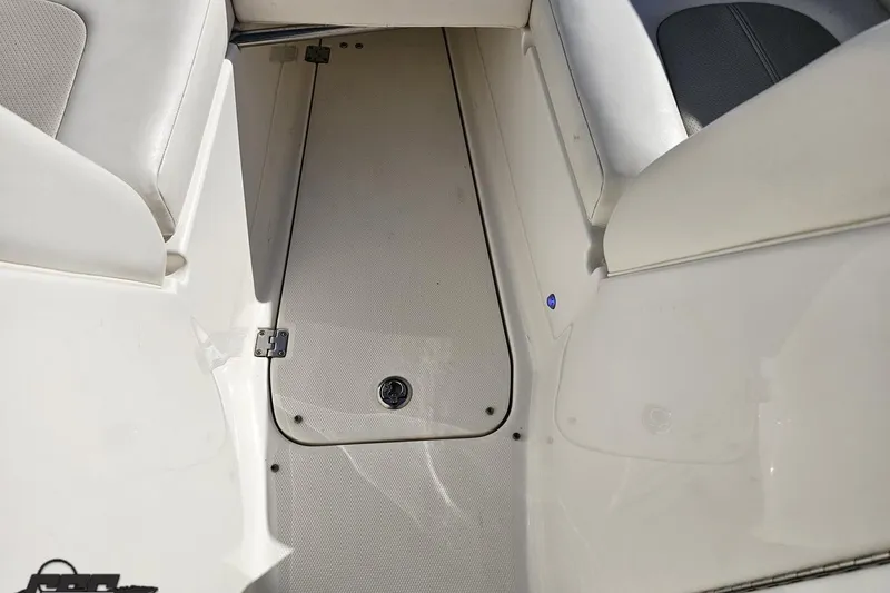 Slide: The Image of Interior view of a 2010 Chaparral 276 SSX boat, featuring white seating and flooring. - 82