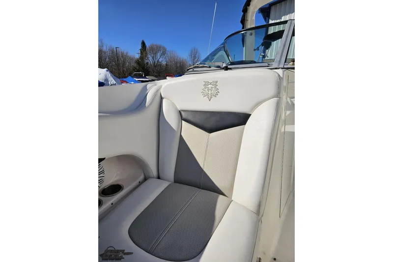 Slide: The Image of 2010 Chaparral 276 SSX boat seat with embroidered logo, featuring beige and gray upholstery. - 85
