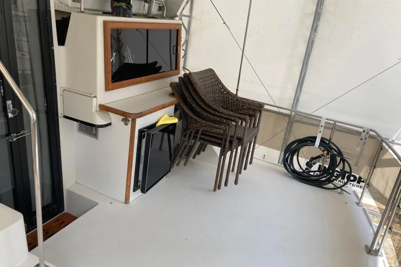 Slide: The Image of Outdoor deck of 1989 Knight & Carver 3807 yacht with stacked chairs and coiled hose. - 13