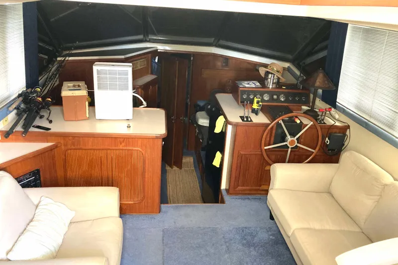 Slide: The Image of Interior of 1989 Knight & Carver 3807 yacht with helm, seating, and fishing rods. - 15