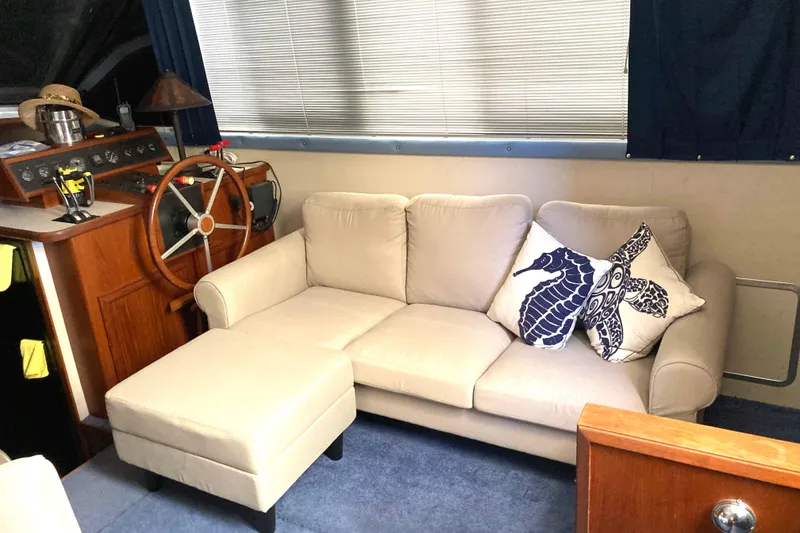 Slide: The Image of Interior of 1989 Knight & Carver 3807 yacht with beige sofa and nautical decor. - 16