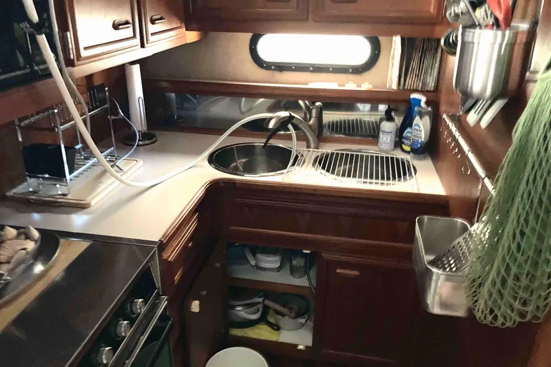 Slide: The Image of Compact kitchen area in a 1989 Knight & Carver 3807 yacht, featuring wooden cabinetry and modern appliances. - 20