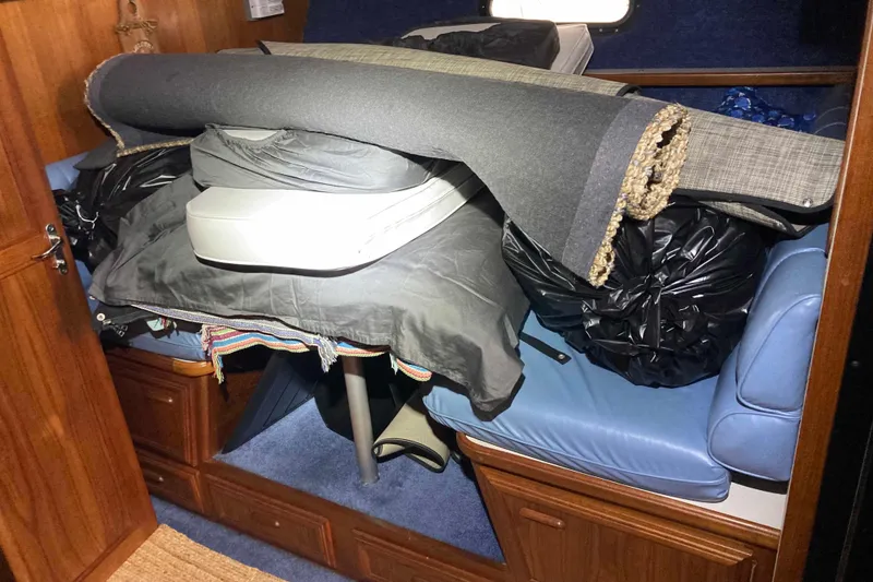 Slide: The Image of Interior of a 1989 Knight & Carver 3807 boat with stored items and rolled carpet. - 21